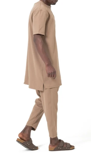 Ensemble Qamis Court Silent Qaba'il – Élégance, confort et modernité pour la saison estivale Découvrez l'Ensemble Qamis Court Silent Qaba'il, une tenue pensée pour les hommes recherchant un équilibre parfait entre élégance, confort et praticité. Inspiré du qamis traditionnel tout en adoptant une coupe moderne, cet ensemble est idéal pour accompagner votre quotidien, vos sorties, vos voyages, vos prières ou encore vos événements. Son design sobre et raffiné en fait une pièce incontournable de la collection Qaba'il, conçue pour répondre aux attentes des hommes qui souhaitent s'habiller avec style tout en respectant une esthétique pudique et intemporelle. L'ensemble se compose d'une tunique à manches courtes associée à un sarouel coupe droite assorti, créant une silhouette harmonieuse et contemporaine. La tunique est dotée d'une encolure zippée discrète, apportant une touche moderne tout en facilitant l'enfilage. Les fentes latérales assurent une excellente liberté de mouvement et améliorent le confort au quotidien. Le sarouel, avec sa coupe droite soigneusement étudiée, complète parfaitement la tenue et offre un tombé élégant. L'Ensemble Qamis Court Silent est confectionné dans notre célèbre tissu Double 100 % polyester, le même tissu utilisé pour notre ensemble Azur, apprécié par de nombreux clients pour sa qualité et sa durabilité. Léger, fluide et agréable au toucher, ce textile offre une excellente tenue tout en restant particulièrement confortable. Contrairement à certains tissus synthétiques, il ne colle pas à la peau et procure une sensation de fraîcheur, même lorsque les températures augmentent. C'est le choix idéal pour les journées estivales ou les climats chauds. Grâce à sa matière résistante, cet ensemble conserve facilement sa forme lavage après lavage. Il froisse peu, sèche rapidement et demande très peu d'entretien, ce qui en fait une tenue pratique pour une utilisation régulière. Que vous soyez à la recherche d'un qamis court homme, d'un ensemble qamis moderne, d'un sarouel assorti ou d'une tenue confortable pour l'été, ce modèle répond parfaitement à vos attentes. Son style minimaliste permet de le porter dans de nombreuses situations. Il convient aussi bien pour une journée de travail, une promenade, un repas en famille, un voyage, une visite à la mosquée ou encore une occasion plus habillée. Il peut être porté avec une paire de baskets pour un look contemporain ou avec des sandales pour un style plus traditionnel. Disponible dans plusieurs coloris soigneusement sélectionnés, chacun pourra choisir la teinte correspondant à son style. L'Ensemble Qamis Court Silent Qaba'il est proposé en Noir, Indigo, Gris, Beige, Écru et Camel, des couleurs faciles à associer et adaptées à toutes les saisons. Afin de convenir au plus grand nombre, il est disponible dans les tailles S, M, L, XL et XXL. Sa coupe confortable permet une excellente aisance sans compromettre l'élégance de la silhouette. Chez Boutique Sunnah, nous sélectionnons des vêtements alliant qualité de fabrication, finitions soignées et confort durable. Cet ensemble reflète parfaitement l'identité de la marque Qaba'il : proposer des vêtements modernes, sobres et adaptés au quotidien des musulmans recherchant des tenues à la fois pratiques et élégantes. Si vous recherchez un ensemble qamis homme, un qamis manches courtes, un ensemble musulman homme, un qamis d'été, un sarouel homme confortable ou une tenue légère et polyvalente, l'Ensemble Qamis Court Silent Qaba'il représente un excellent choix. Son tissu premium, sa coupe moderne et son confort exceptionnel en font une pièce indispensable de votre dressing. Commandez dès maintenant votre Ensemble Qamis Court Silent Qaba'il sur Boutique Sunnah et profitez d'une tenue élégante, légère et agréable à porter au quotidien. Choisissez votre couleur préférée et trouvez la taille qui vous convient pour découvrir tout le savoir-faire Qaba'il à travers un ensemble conçu pour durer et vous accompagner tout au long de la saison.